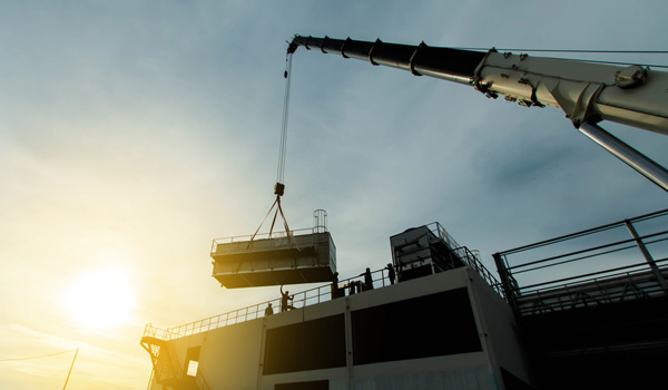 Cran lifting heavy loads onto a roof
