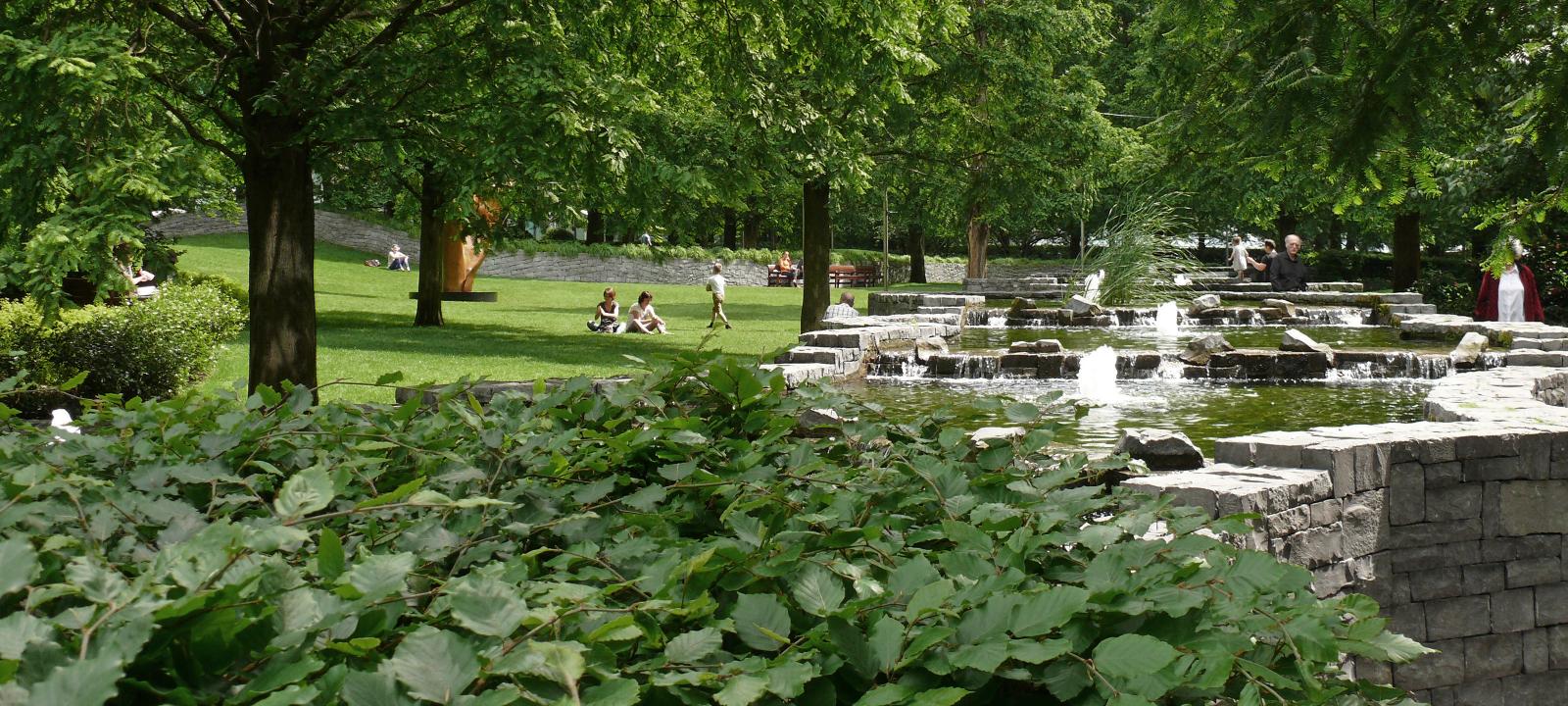 Water feature with fountains, surrounded by shrubs and trees