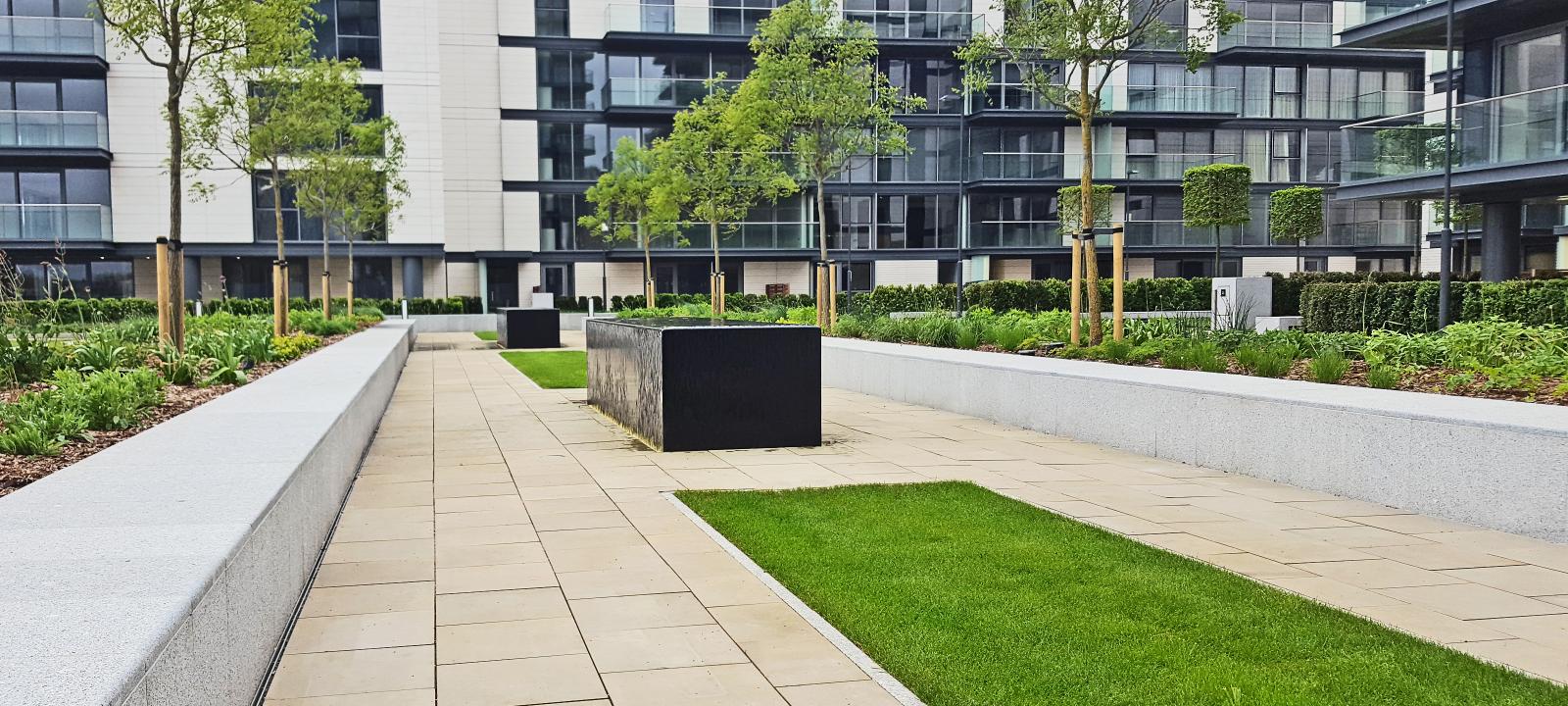 Pathways, lawn and planting beds surrounded by residential buildings