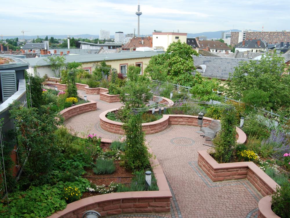 Roof garden with plant beds and walkways bordered by stone walls