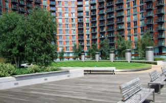 Courtyard with lawn, walkways and benches surrounded by high residential buildings