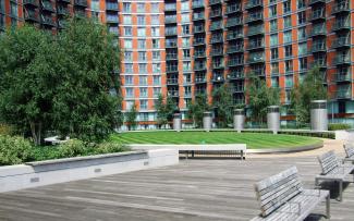 The podium over the underground garage is designed as a park and is a courtyard accessible to the public. Courtyard with lawn, walkways and benches surrounded by high residential buildings