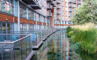 On the balconies, you feel as if you are standing on a jetty thanks to the water channel that runs right up to the building facade. Water channel adjoining balconies of a residential building