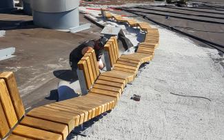 Wooden benches being constructed on a pitched roof