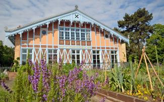 Herb and vegetable plots in front of a historic building