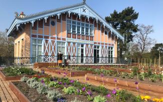 Herb and vegetable plots in front of a historic building