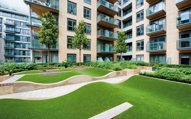 Courtyard with rolling mounds made from grass surrounded by residential blocks